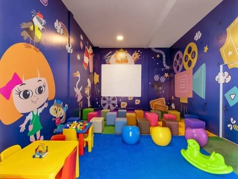 Espaço infantil colorido do Jardins de Jurema com personagens nas paredes e brinquedos