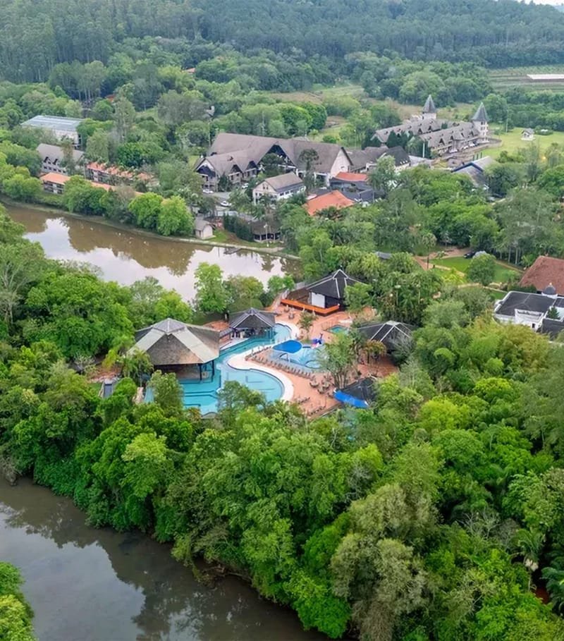 Vista aérea do Lagos de Jurema com piscinas, chalés e lago cercados por mata