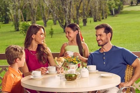 Família tomando café da tarde ao ar livre no gramado do Lagos de Jurema